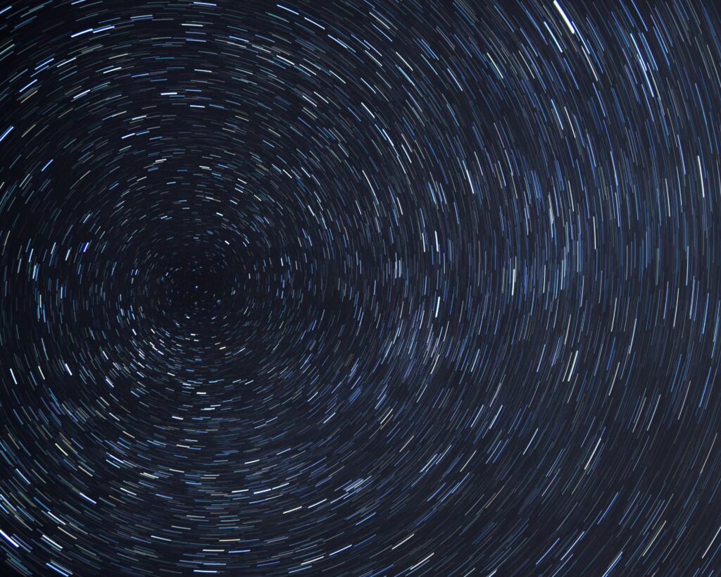 Dazzling star trails creating a spiral effect in the clear night sky.