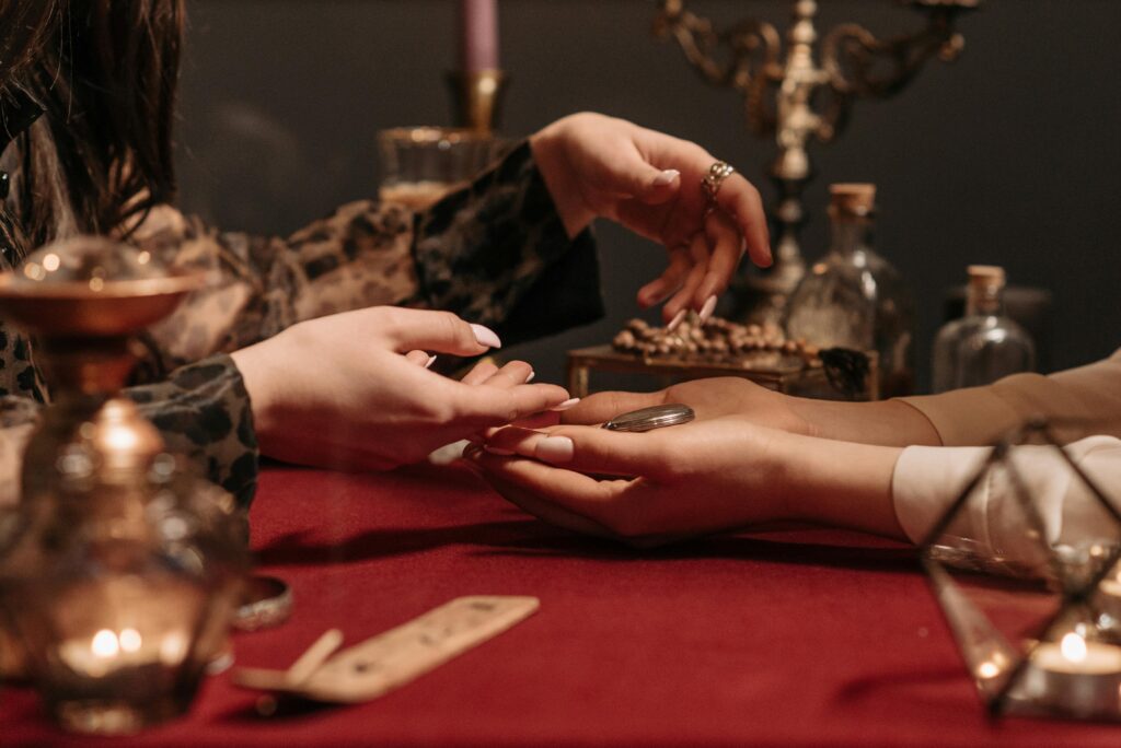 A fortune teller delicately reading a client's palm in a mystic setting with enchanting ambiance.